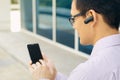 Businessman Calling On Mobile Phone With Bluetooth Headset