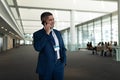 Businessman calling someone on mobile phone and looking away in office lobby Royalty Free Stock Photo