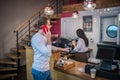 Businessman calling wife while standing in cafeteria and waiting