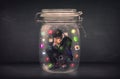 Businessman captured in a glass jar with colourful app icons concept