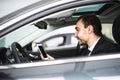 Businessman in car reading message or smth on smartphone Royalty Free Stock Photo