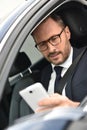 Businessman in car with smartphone Royalty Free Stock Photo