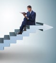 Businessman in career ladder concept reading book