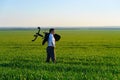 Businessman carries an office chair in a field to work, freelance and business concept, green grass and blue sky as background