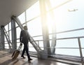 Businessman carrying baggage, moving to boarding gate in airport Royalty Free Stock Photo