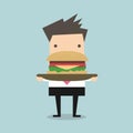 Businessman carrying a big hamburger with a beef patty and trimmings