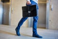 Cropped image of businessman carrying briefcase bag while walking against elevator in office Royalty Free Stock Photo