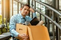 Businessman is carrying a brown cardboard box to resignation. Depressed Businessman sitting on ground stairs suffering emotional s Royalty Free Stock Photo