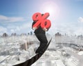 Businessman carrying 3D red percentage sign balancing on wire