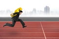 Businessman carrying golden dollar sign running on track