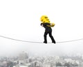 Businessman carrying golden euro sign balancing on tightrope Royalty Free Stock Photo