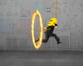 Businessman carrying golden euro sign jumping through fire hoop Royalty Free Stock Photo