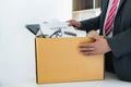 Businessman carrying packing up all his personal belongings and files into a brown cardboard box to resignation in modern office, Royalty Free Stock Photo