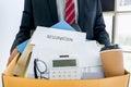 Businessman carrying packing up all his personal belongings and files into a brown cardboard box to resignation in modern office, Royalty Free Stock Photo