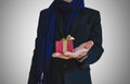 Businessman in casual suit with little gift box on hand, selective focus on gift box