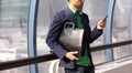 Businessman in casual wear with trendy leather bag and cell phone inside modern office building. Young urban professional business Royalty Free Stock Photo