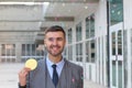 Businessman celebrating while holding a huge coin Royalty Free Stock Photo