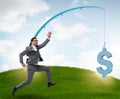 Businessman chasing money on fishing rod Royalty Free Stock Photo