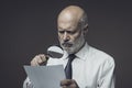 Businessman checking a document with a magnifier Royalty Free Stock Photo