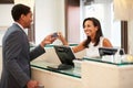 Businessman Checking In At Hotel Reception Front Desk Royalty Free Stock Photo