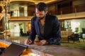 Businessman checking in at hotel. Young handsome businessperson filling out information form at the front desk reception