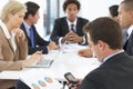 Businessman Checking Phone During Meeting In Office