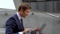 Businessman checking stock market using laptop on stairs outdoors office center Royalty Free Stock Photo