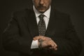 Businessman checking time on his wrist watch. Close up portrait of business man looking at clock on hand. Front view of Royalty Free Stock Photo