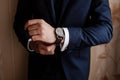 Businessman checking time on his wrist watch, groom getting ready in the morning before wedding ceremony