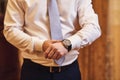 Businessman checking time on his wrist watch, man putting clock on hand,groom getting ready in the morning before wedding ceremony Royalty Free Stock Photo