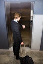 Businessman checking time while waiting for elevator Royalty Free Stock Photo