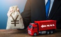 Businessman with chinese yuan or japanese yen money bag and truck. High income of the transport business and the transport of Royalty Free Stock Photo