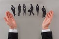 Businessman choosing candidate from paper figurines. Royalty Free Stock Photo