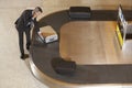 Businessman Claiming Suitcase At Luggage Carousel In Airport