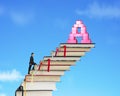 Businessman climbing books stairs toward alphabet A shape blocks Royalty Free Stock Photo