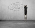 Businessman climbing and drawing app icon on concrete wall Royalty Free Stock Photo