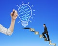 Businessman climbing money stairs toward light bulb hand drawing Royalty Free Stock Photo