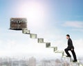 Businessman climbing spiral staircase toward treasure chest on m Royalty Free Stock Photo