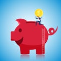 Businessman climbing to the top of giant piggy bank and putting gold coin to save money. Saving money concept. Royalty Free Stock Photo