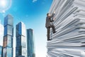 Businessman climbing up a huge stack of paper Royalty Free Stock Photo