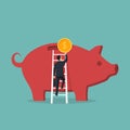 Businessman climbs stairs to big piggy bank hold coin in hand Royalty Free Stock Photo