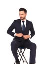 Businessman closing his suit and looks to side while sitting Royalty Free Stock Photo