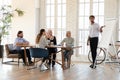 Confident businessman coach making flip chart presentation to diverse employees