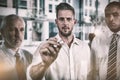 Businessman with colleagues writing on glass with marker