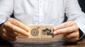 Businessman collects wooden blocks with the image of the goal and money. The concept of doing business and finance. Setting goals