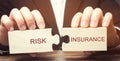 Businessman collects wooden puzzles with the word Risk insurance. The transfer of certain risks to the insurance company. Banking Royalty Free Stock Photo