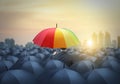 Businessman with colorful rainbow umbrella among others, unique