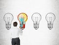 Businessman coloring a light bulb sketch Royalty Free Stock Photo