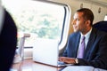 Businessman Commuting To Work On Train And Using Laptop Royalty Free Stock Photo