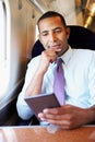 Businessman Commuting On Train Reading A Book